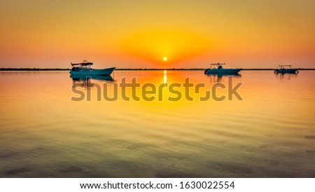 Fishing boat in Dammam seaside with yellow sunrise background - Dammam, Saudi Arabia