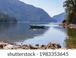 fishing boat docked in calm Harrison Lake of a dreamy landscape with beautiful mountain in British Columbia, Canada. Travel photo, street view, concept photo nature.