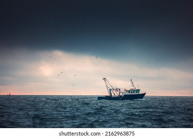 Fishing boat and fisherman in the sea, foggy morning over the water.