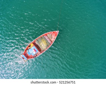 Fishing boat floating in the sea. The beautiful bright blue water in a clear day.The sun shines the light reflected off the surface.Top view.