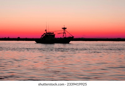 Fishing boat leaving port at nightfall. Fishing industry in andalusian coast, Spain  - Powered by Shutterstock