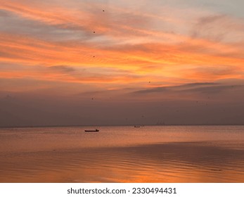 Fishing boat on the coast of puttalam Sri Lanka and beutiful orange yellow skies during a sunset