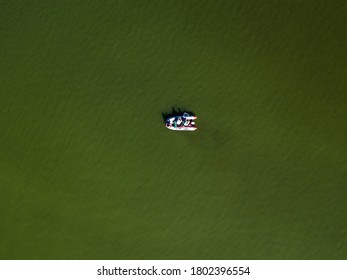 Fishing Boat On Green Water, Aerial Drone View. Algae Bloom In The River, Green Pattern On The Water.