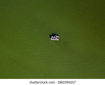 Fishing Boat On Green Water, Aerial Drone View. Algae Bloom In The River, Green Pattern On The Water.