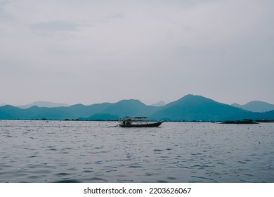 Fishing Boat In Open Water, With Beautiful Mountain View.