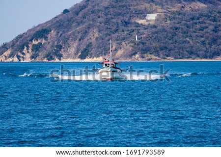 Fishing boat returning to port , Takamatsu city, kagawa, shikoku, japan