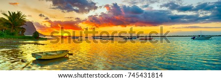 Fishing boat at sunset time. Le Morn Brabant on background. Mauritius. Panorama landscape