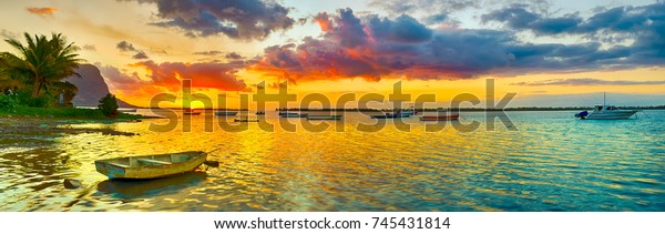 Fishing boat at sunset time. Le Morn Brabant on background. Mauritius. Panorama landscape ocean waves mural ideas.