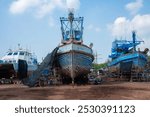 Fishing boat waiting for maintenance, to be repaired and painted at repair yard for boats, Fishing Boat maintenance concept