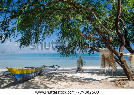 fishing boats an nets on areia branca tropical beach in dili east timor leste