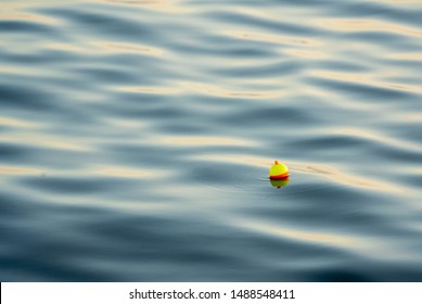 Fishing Bobber On The Water In Late Afternoon With Room For Copy