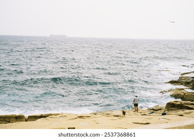 Fishing by the rocky shoreline - Powered by Shutterstock