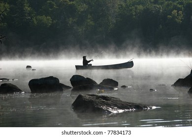 Fishing From A Canoe On A Misty Morning