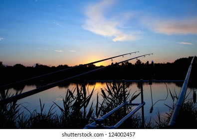 fishing carp sunrise - silhouette spinning on rod pod