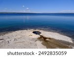 Fishing Cone geyser on the shore of blue beautiful Yellowstone Lake, at West Thumb Geyser Basin in Yellowstone National Park, USA