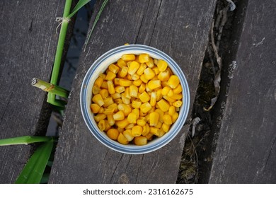 Fishing. Corn in a can on the wooden pier. Fishing bait. Corn fishing. - Shutterstock ID 2316162675