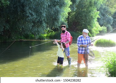 Fishing. Grandson With Father And Grandfather Fishing By Lake. Family Generation And People Concept. Family Fishermen Fishing With Spinning Reel