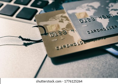 Fishing hook with credit cards on laptop, closeup. Cyber crime
