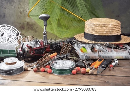 Fishing items on a table in a composition, wooden background.