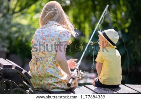 Fishing. Mother and son spending time together. Summer day, catching fish in the lake