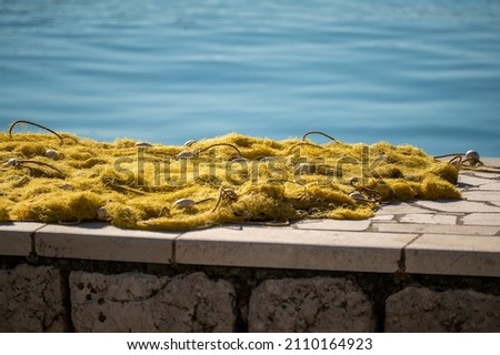 fishing nets dry on shore. Fishing net near dock. Stacked yellow coloured fishing nets. fishing nets dry on shore near dock. Yellow coloured fishingnets