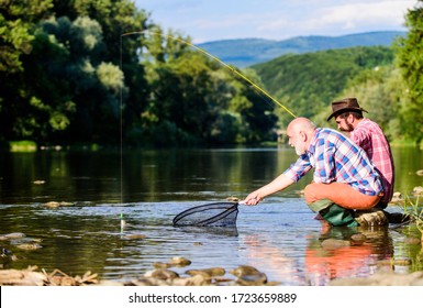 Fishing on the lake. fly fish hobby of men. retirement fishery. happy fishermen friendship. Catching and fishing. retired dad and mature bearded son. Two male friends fishing together.