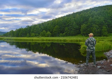 Fishing On The Russian Far East. Fisherman With A Spinning Rod Catching Fish. Khabarovsk Krai, Strait Of Tartary Coast, Hunger River. 