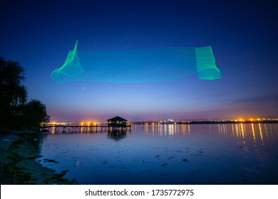 Fishing pier with lake house at night with drone imitating northern Aurora Borealis lights - Powered by Shutterstock