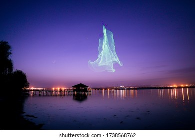 Fishing pier with lake house at night with drone imitating northern Aurora Borealis lights - Powered by Shutterstock