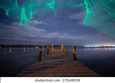 Fishing pier at night with drone imitating northern Aurora Borealis lights - Powered by Shutterstock