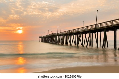 Fishing Pier at Sunrise at Virginia Beach, Virginia, USA. Virginia Beach, a coastal city in southeastern Virginia, lies where the Chesapeake Bay meets the Atlantic Ocean.