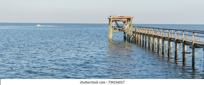 Fishing Piers Stretching Out Over Galveston Bay In Kemah, Texas, USA. Foot Pier For Saltwater Fishing Of Vacation Home/beach House Rental/bay Home In Lighthouse District Waterfront At Sunset. Panorama