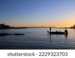 Fishing for pike with high speed bass boat in the sunset. Fisherman casting in the last rays of light, on Lake Vänern. Scandinavia, Sweden.