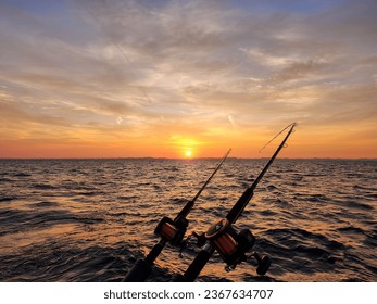 Fishing poles with sunrise glowing over Lake Michigan horizon - Powered by Shutterstock