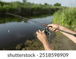 Fishing in river. A fisherman with a fishing rod on the river bank. Man fisherman catches a fish. Fishing, spinning reel, fish, Breg rivers. - The concept of a rural getaway. Article about fishing.