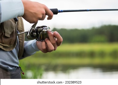 Fishing in river.A fisherman with a fishing rod on the river bank. Man fisherman catches a fish.Fishing, spinning reel, fish, Breg rivers. - The concept of a rural getaway. Article about fishing. - Powered by Shutterstock