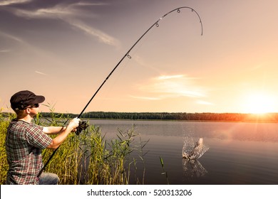 fishing rod lake fisherman men sport summer lure sunset water outdoor sunrise fish - stock image 