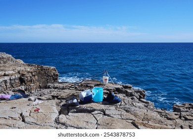 Fishing rod on the rocks on a sunny day in Italy - Powered by Shutterstock