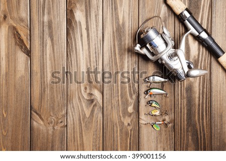 the fishing rod stand on the wooden background.