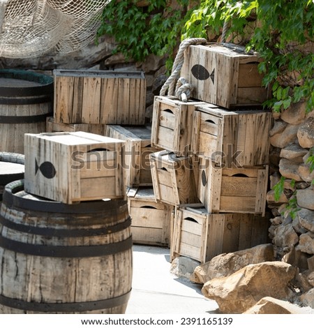 Fishing still life, wooden boxes and fish barrels including a fishing net