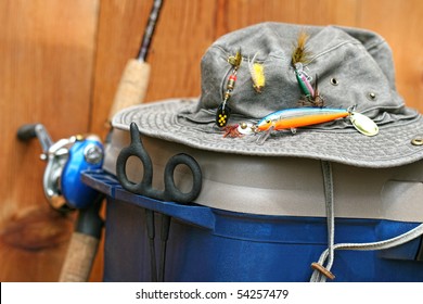 Fishing tackle box, hat and reel on wood