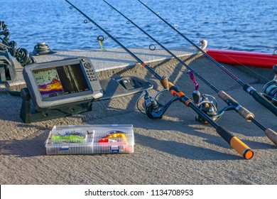 Fishing tackle set and fishfinder, echolot, sonar at the boat. Spinning rods with reels and lures