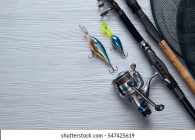 Fishing Tackle - Fishing Spinning, Hooks And Lures On Light Wooden Background.Top View.