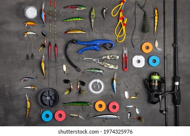 Fishing Tackle - Fishing Spinning Rod, Hooks And Lures On Gray Background. Active Hobby Recreation Concept. Top View, Flat Lay.