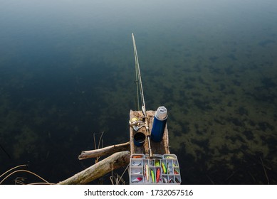 Fishing Tackle - Fishing Spinning, Rod, Reel, Hooks, Fly, Bait, Lures In Box On Wooden Pier On Pond Background. Top View. Fishing For Pike, Perch. Recreation. Fishing Day. Vintage Banner For Design.