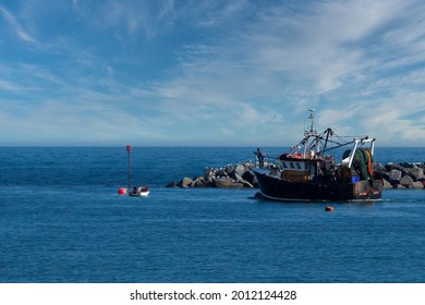 Fishing Trawler Leaving The Safty Of The Harbour At Lyme Regis Dorset England On The 18th June 2021