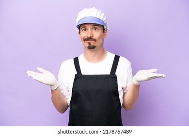 Fishmonger Man Wearing An Apron Isolated On Purple Background Having Doubts While Raising Hands