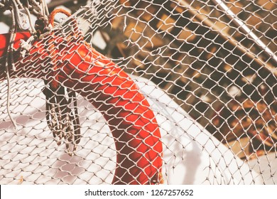 Fishnet. Fishing net and lifebuoy. Background from a fishing net. Weaving. Braided rope. Fishing. - Powered by Shutterstock