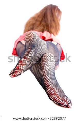 Fishnet stockings and red paint toes. A woman poses her feet and soles.