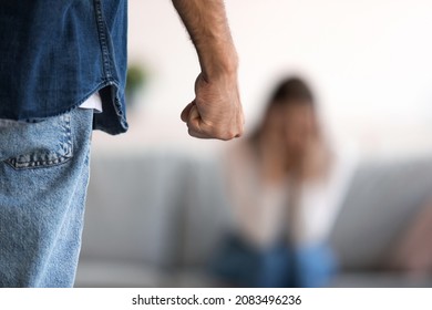 Fist of angry aggressive millennial caucasian husband and crying wife afraid of domestic violence in room interior. Social problems at home, fear, crisis and bad relationship, close up, unrecognizable - Shutterstock ID 2083496236